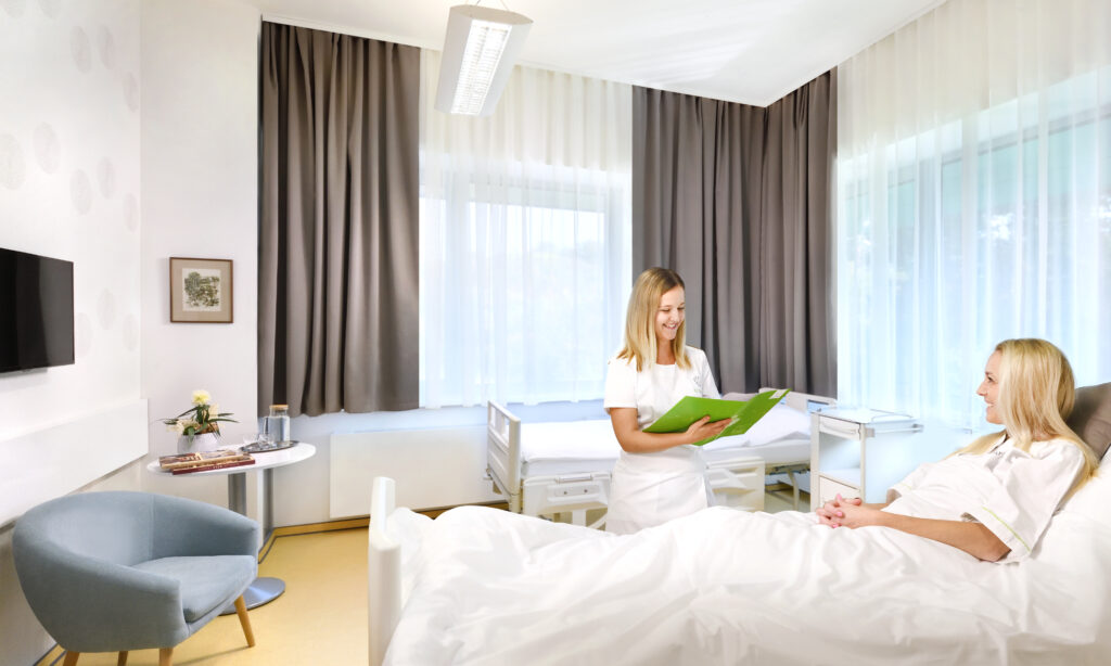 žena oddychujúca na lôžku v príjemnej moderne a útulne zariadenej izbe po zákroku jednodňovej chirurgie z oblasti gynekológie